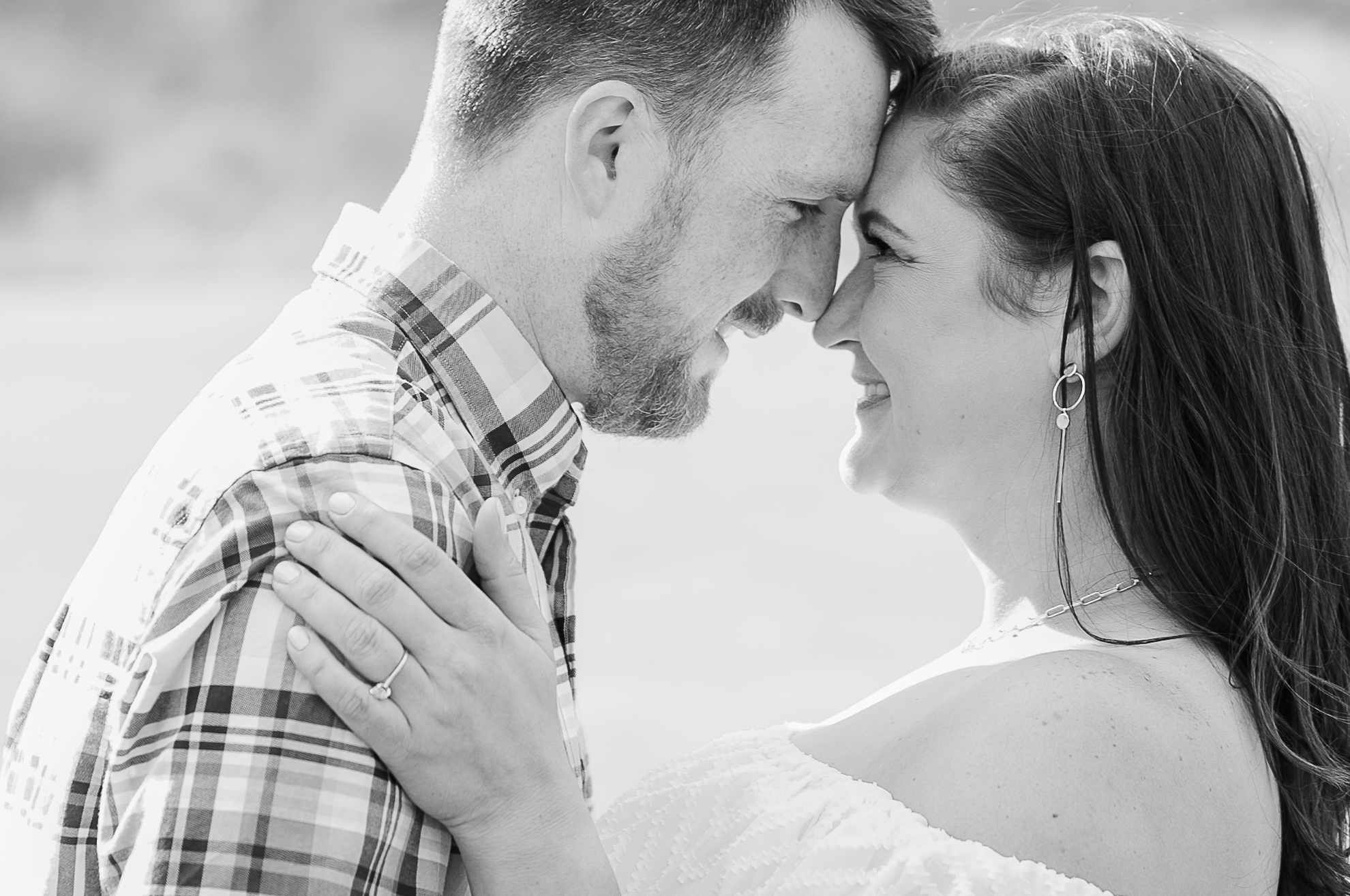 Bride and Groom stand embracing with forheads touching at engagement photos